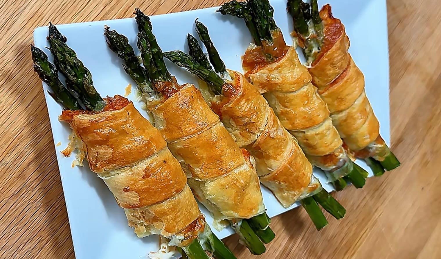 Puff Pastry Asparagus bundles wrapped with Prosciutto di Parma and sharp provolone baked until golden brown and flaky.