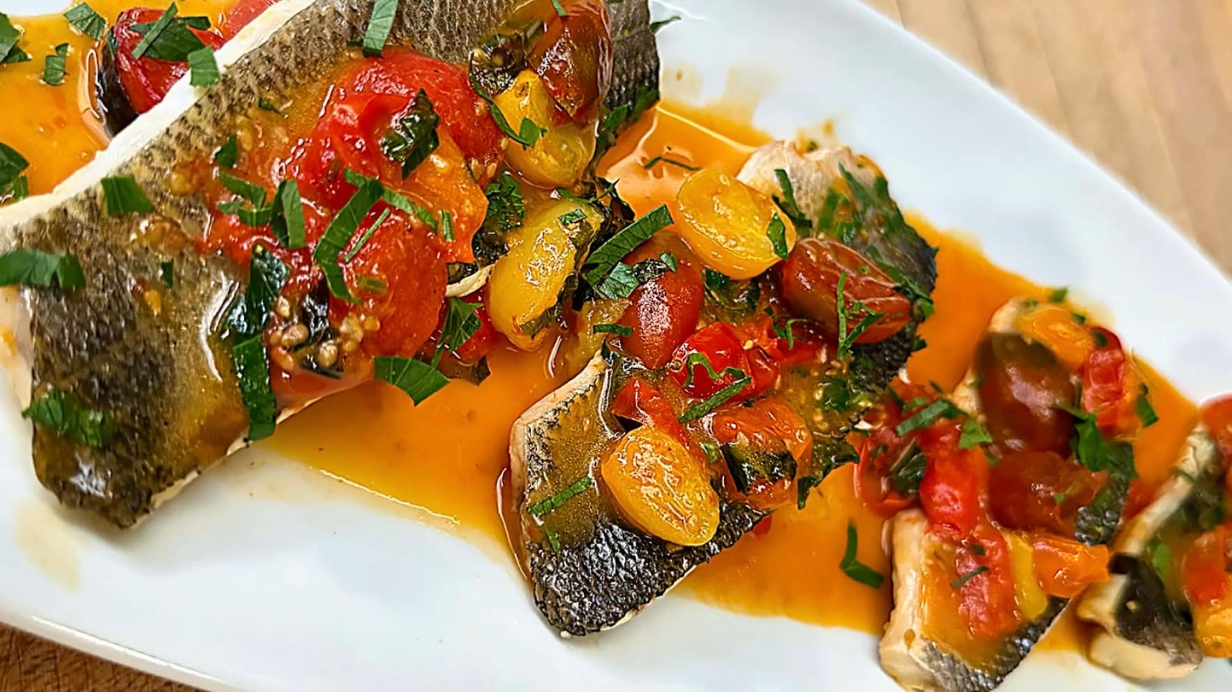 Branzino all’Acqua Pazza with cherry tomatoes, garlic, olive oil, and fresh herbs simmered in a light Mediterranean broth.