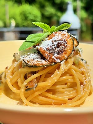 Spaghetti alla Nerano made with fried zucchini, Parmigiano Reggiano, basil, and extra virgin olive oil.