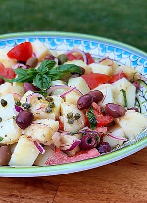 Insalata Pantesca with red potatoes, tomatoes, capers, olives, red onion, basil, and extra virgin olive oil.