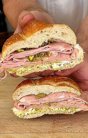 Mortadella sandwich with stracciatella cheese, pistachio pesto, and crushed pistachios served on fresh Italian bread.