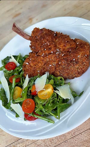 Veal Chop with an arugula salad with cherry tomatoes and shaved parmigiano