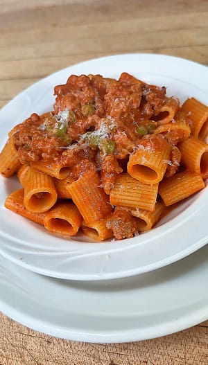 Mezzi Rigatoni with Sausage and Peas in a creamy tomato sauce finished with Parmigiano Reggiano