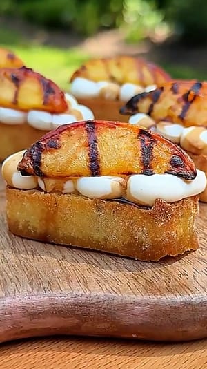 Grilled Peach Crostini with Whipped Ricotta topped with caramelized peaches and balsamic glaze.