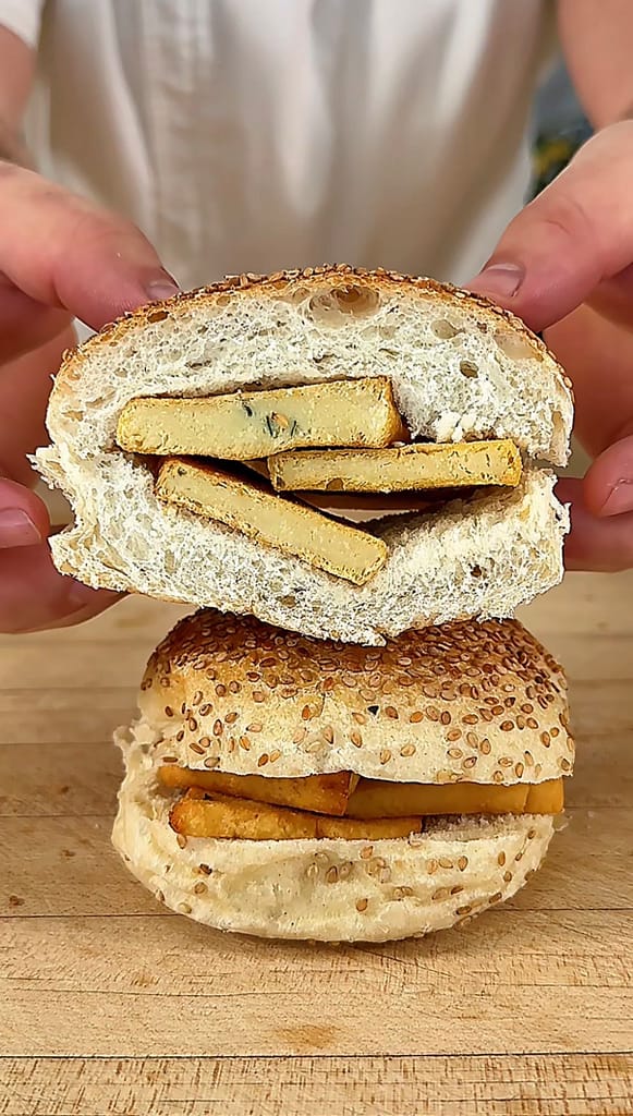 Sicilian Panelle served on a sesame roll with fresh lemon, traditional Palermo-style chickpea fritters.