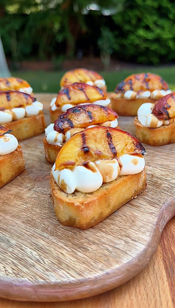 Grilled Peach Crostini with Whipped Ricotta topped with caramelized peaches and balsamic glaze.